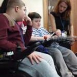 Takin’ Charge Manager Dr Janet Hoskin with young people with Duchenne.