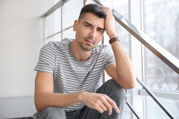 Unhappy young man sitting on stairs