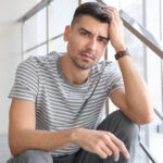 Unhappy young man sitting on stairs