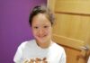 How church helped my daughter during lockdown Ruby, wearing a white shirt and holding a cake while smiling happily at the camera