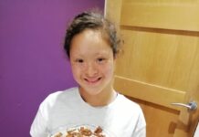 How church helped my daughter during lockdown Ruby, wearing a white shirt and holding a cake while smiling happily at the camera