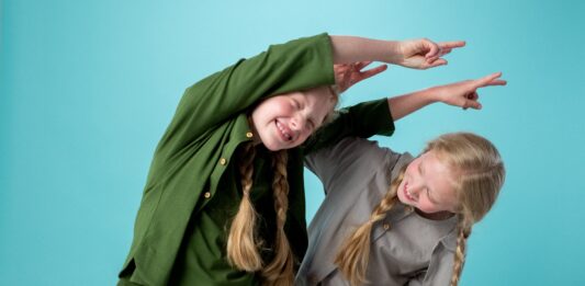 Two girls with long blonde plaits playing together