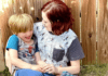 The Challenges of Being an Autistic Mother with Autistic Children A photo of Alicia and her son. They are both wearing short-sleeved shirts and Alicia is smiling at her son