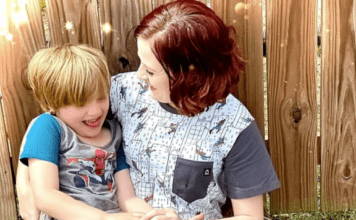 The Challenges of Being an Autistic Mother with Autistic Children A photo of Alicia and her son. They are both wearing short-sleeved shirts and Alicia is smiling at her son