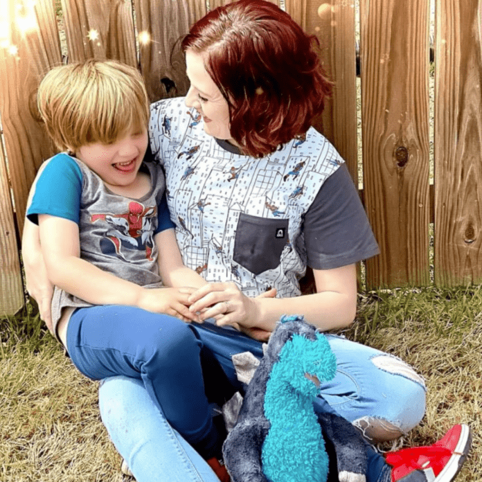 Ein Foto von Alicia und ihrem Sohn. Sie tragen beide kurzärmelige Hemden und Alicia lächelt ihren Sohn an