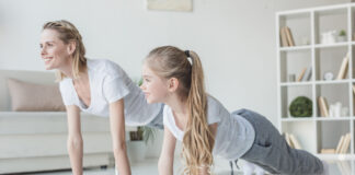The Benefits of Yoga for SEND Pupils a woman and child doing yoga together wearing matching grey-white outfits