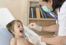 Designing and managing a health testing programme for your school A woman testing a young boy for illness