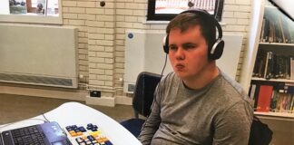 Living with a rare disease: Bardet-Biedl Syndrome A photo of Ben, a young adult with BBS, sitting at a computer wearing headphones