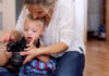 The future of Down’s Syndrome therapy is just around the corner A handicapped down syndrome boy and his mother with a digital camera indoors, taking pictures.