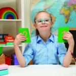 A girl with Down syndrome is sitting at a desk