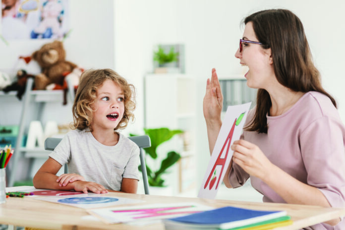 Speech therapist teaching letter a young boy in a classroom